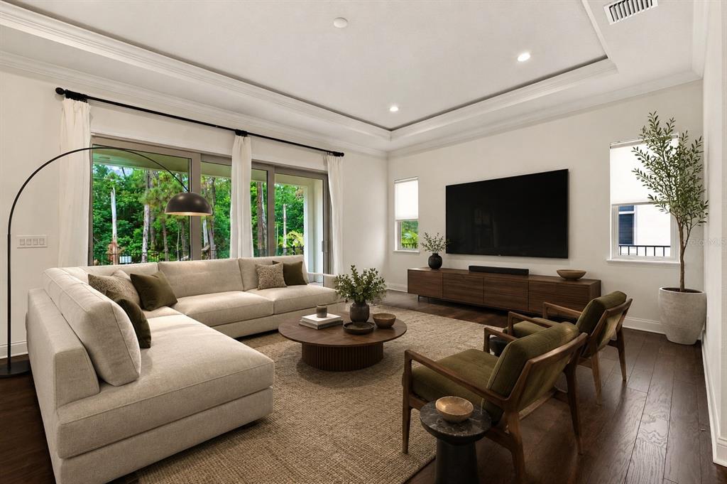 A living room features a large sectional sofa, two armchairs, a television, and floor-to-ceiling windows — 10134 ROYAL ISLAND COURT, ORLANDO, FL