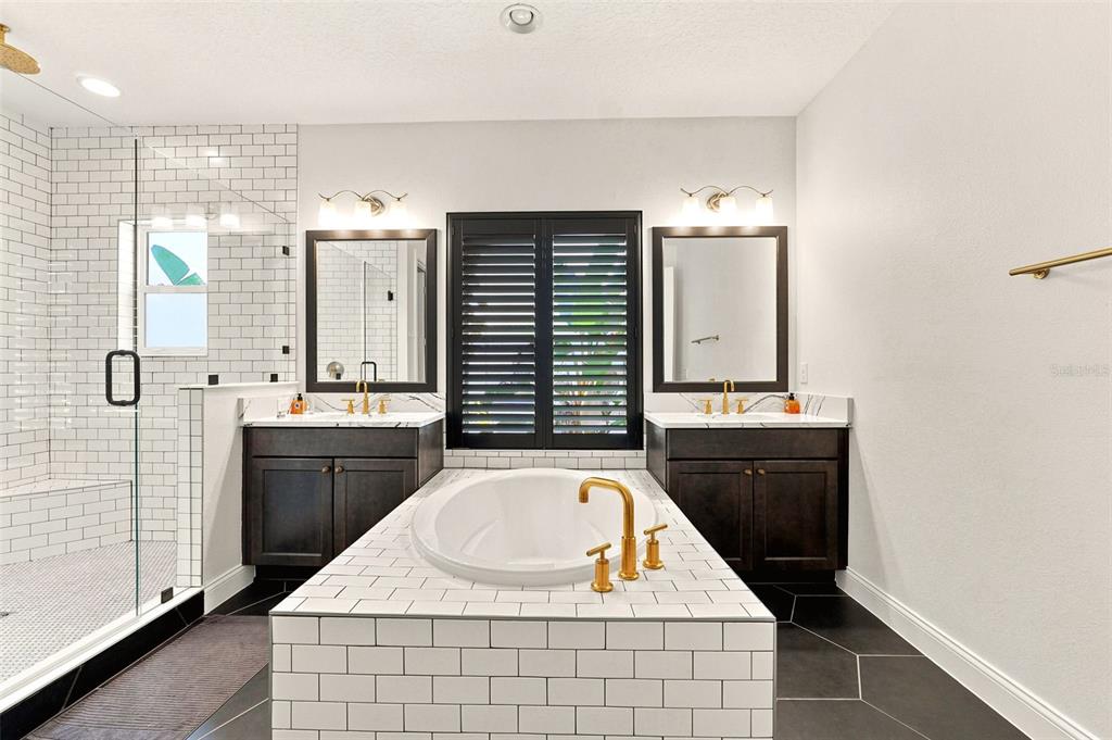 A bathroom features a central soaking tub, dual vanities, and a glass-enclosed shower — 10134 ROYAL ISLAND COURT, ORLANDO, FL