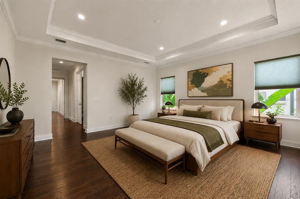 A bedroom features a tray ceiling, dark wood floors, a king bed, and a jute rug — 10134 ROYAL ISLAND COURT, ORLANDO, FL