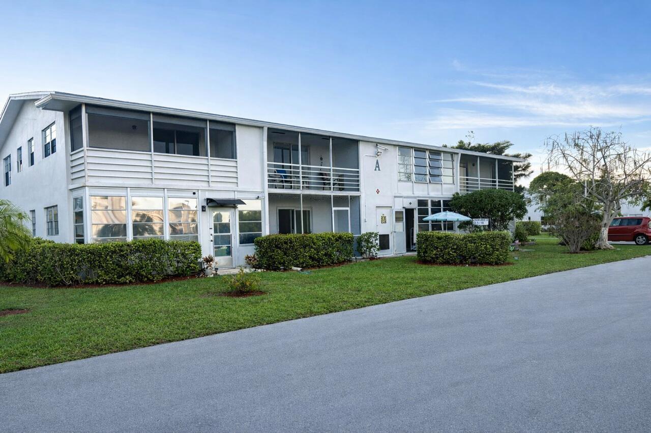 A two-story white apartment building with screened balconies and a grassy front lawn — 7 Lyndhurst A, Deerfield Beach FL 33442, DEERFIELD BEACH, FL