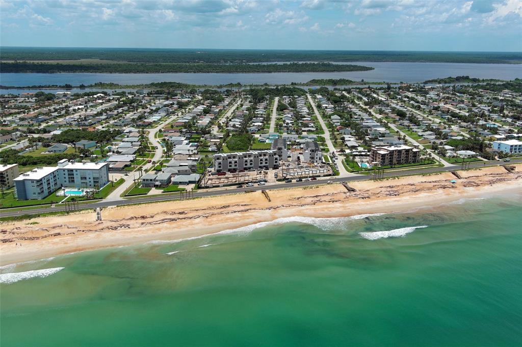 An aerial view shows a coastal neighborhood with a beach, ocean, and a construction site — 2360 OCEAN SHORE BOULEVARD UNIT 30, ORMOND BEACH, FL