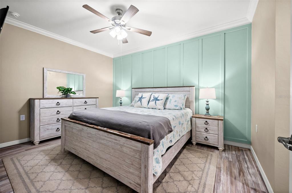 A bedroom features a light wood bed frame, matching dresser, and a mint green accent wall — 43020 GREENWAY BOULEVARD UNIT 312, PUNTA GORDA, FL