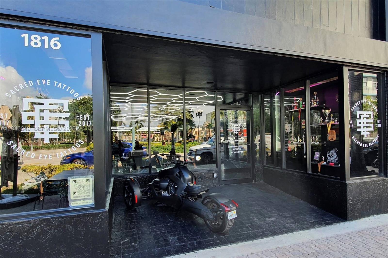 The exterior of a tattoo shop features a black storefront with a parked three-wheeled motorcycle — 1816 Harrison St, Hollywood FL 33020, HOLLYWOOD, FL