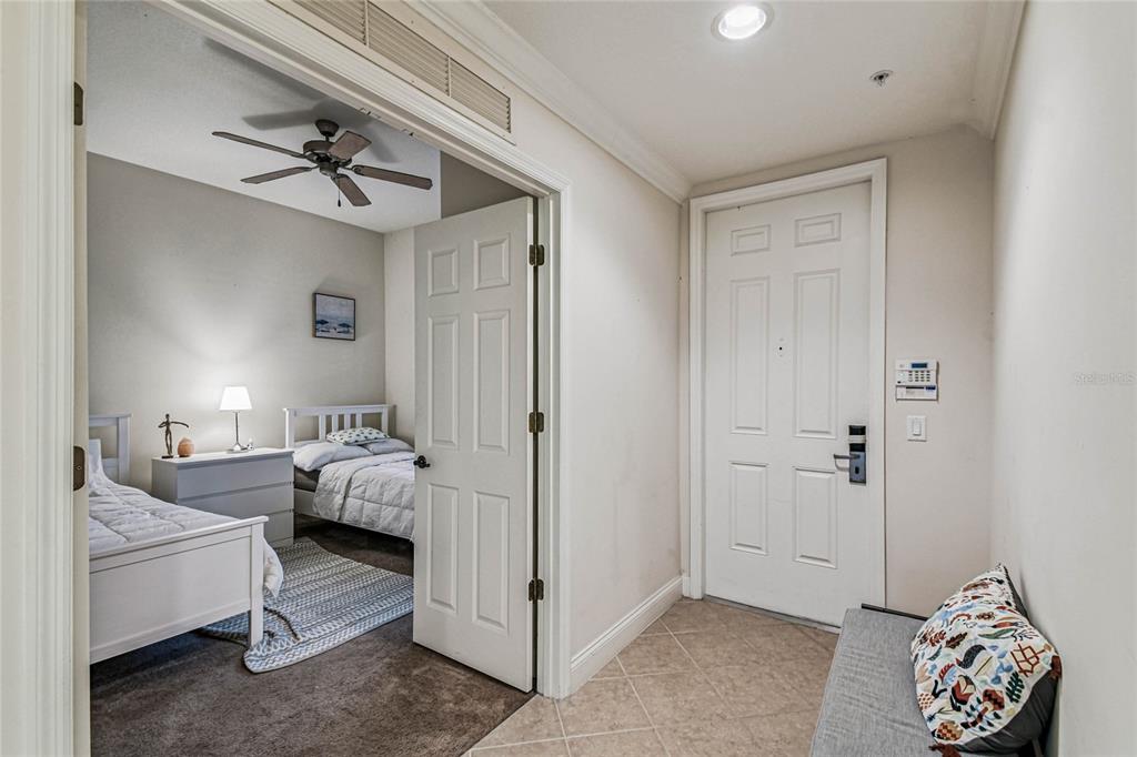 A view from a tiled entryway looking into a bedroom with two twin beds — 1501 NORTHERN HARRIER WAY UNIT 302, REUNION, FL
