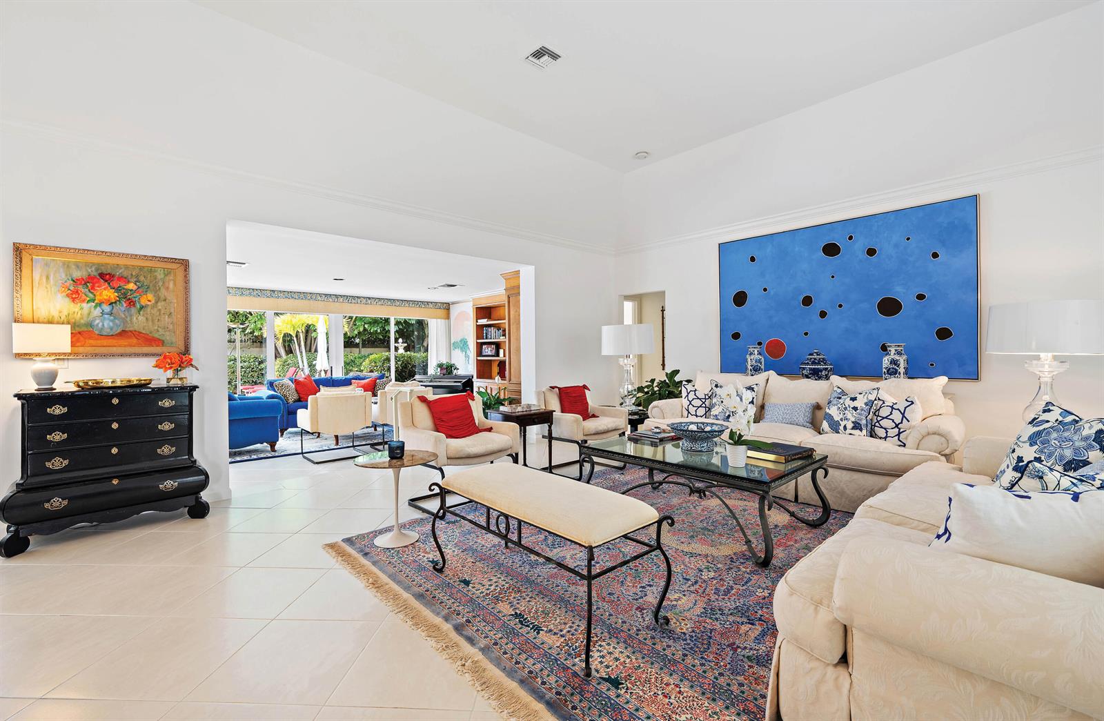 A bright living room features white walls, a large blue abstract painting, and tile flooring — 11337 Lost Tree Way, North Palm Beach FL 33408, NORTH PALM BEACH, FL