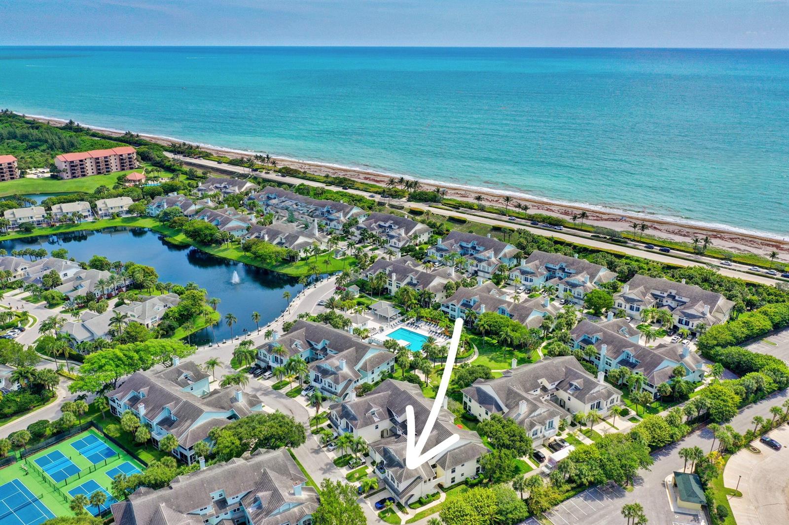 An aerial view of a coastal residential complex featuring a swimming pool and palm trees — 1609 Mizzenmast Way # 1609, Jupiter FL 33477, JUPITER, FL