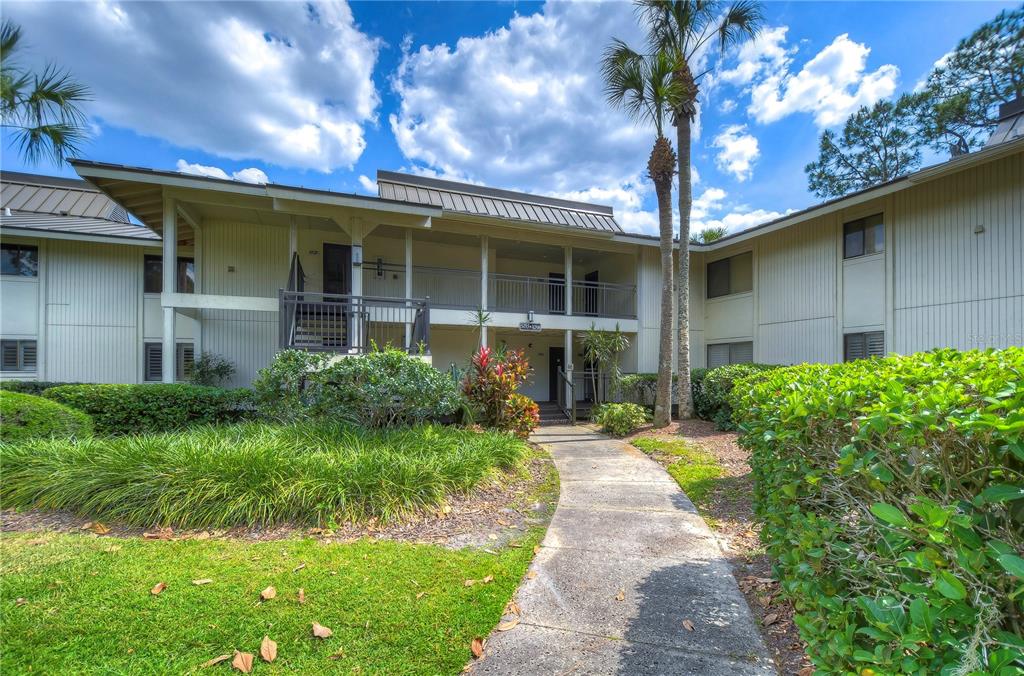 A two-story apartment building with light-colored siding, a walkway, and surrounding landscaping — 29300 BAY HOLLOW DRIVE UNIT 3258, WESLEY CHAPEL, FL