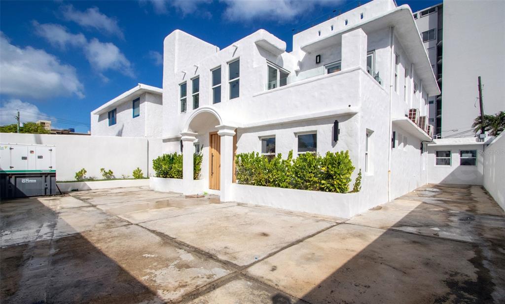A white two-story stucco building with a paved driveway and a front entrance archway — 2071 CACIQUE STREET, SAN JUAN, PR