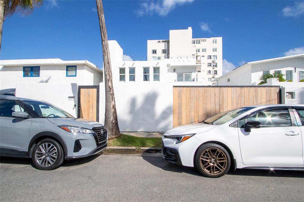 A white exterior building with a wooden gate is parked in front of two cars — 2071 CACIQUE STREET, SAN JUAN, PR