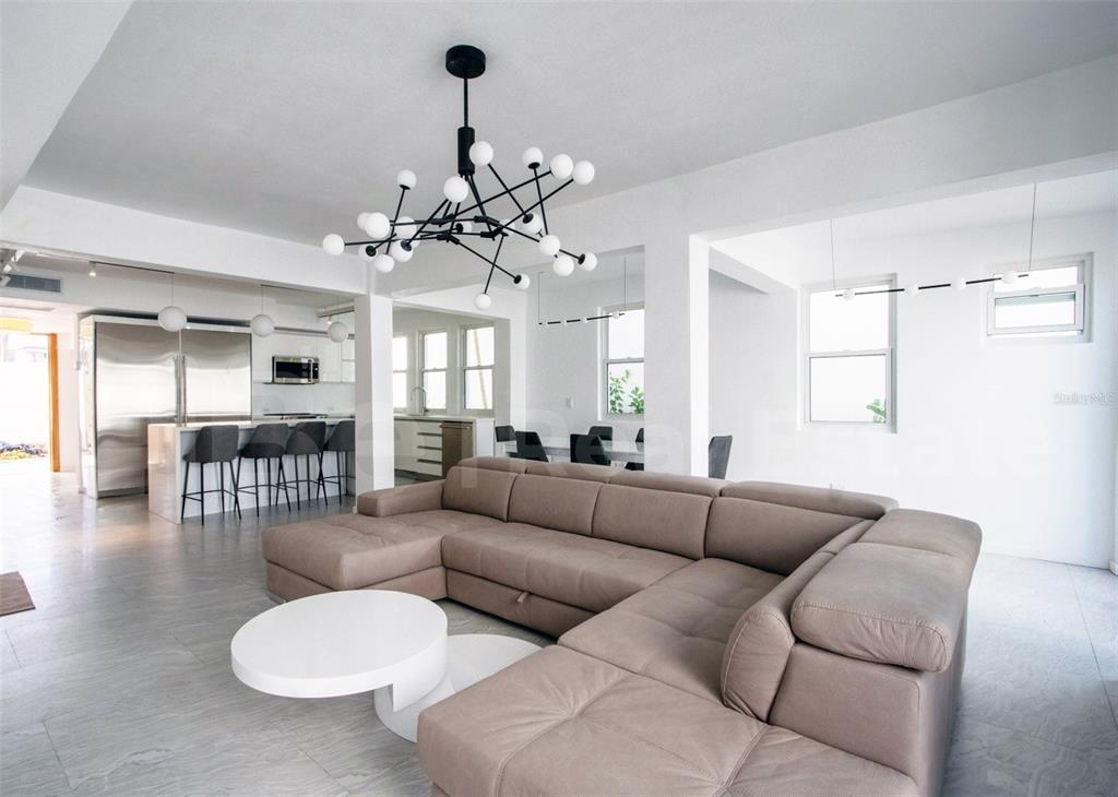A modern living room features a large beige sectional sofa, a white coffee table, and a chandelier — 2071 CACIQUE STREET, SAN JUAN, PR