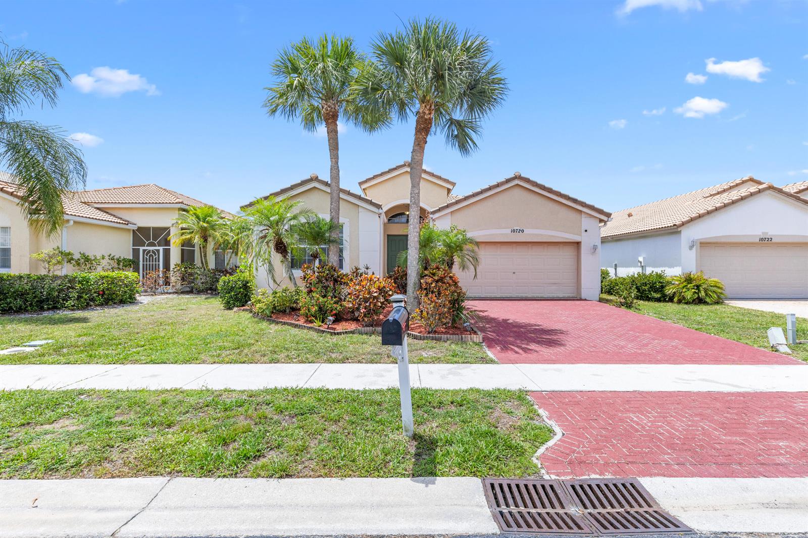 A single-story suburban house features a red brick driveway, two palm trees, and landscaping — 10720 Oak Bend Way, Wellington FL 33414, WELLINGTON, FL