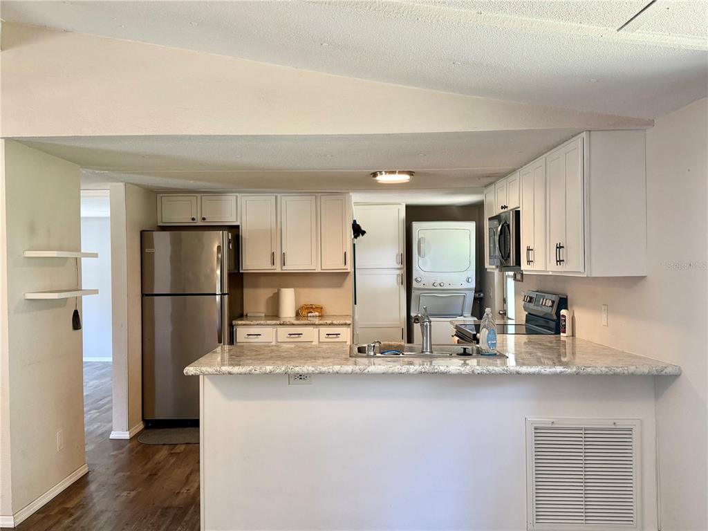 A single-story mobile home with green siding, a front porch, and a detached storage shed — 6655 NW 49TH COURT, OCALA, FL
