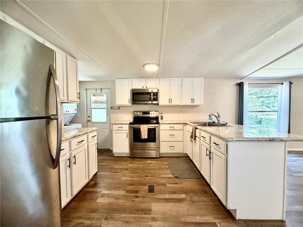 A covered wooden porch leads to a front door on the side of a home — 6655 NW 49TH COURT, OCALA, FL