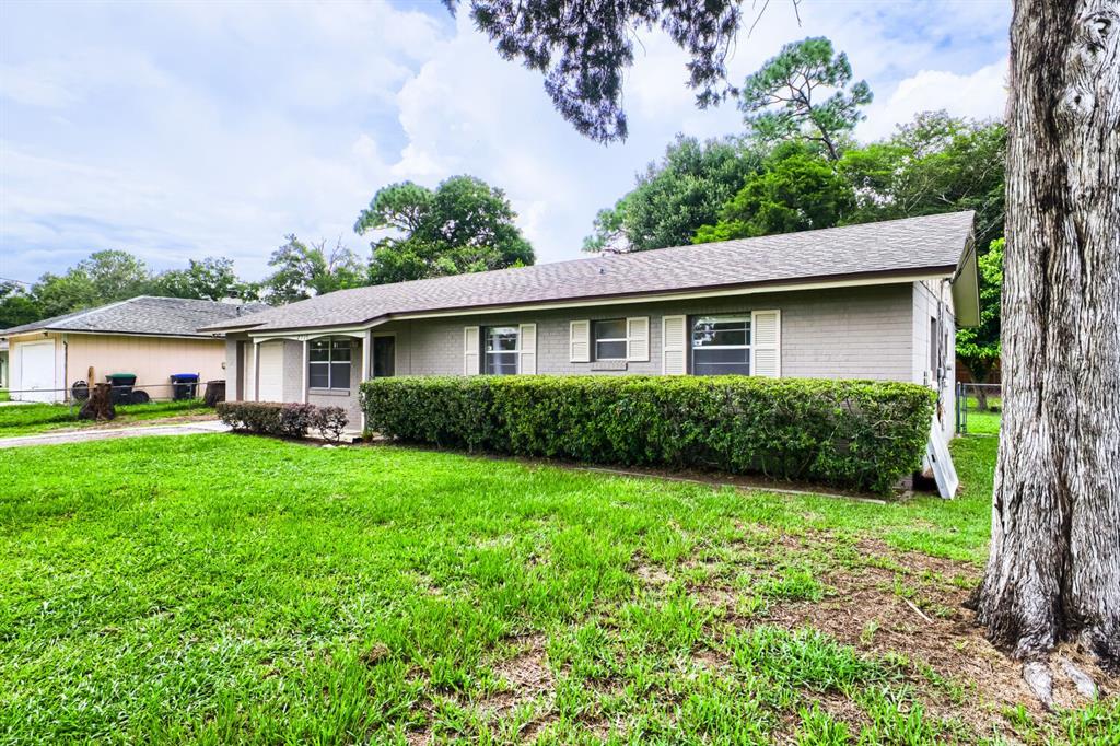 A single-story gray brick house with a shingled roof and a large front hedge — 2715 RAMSEY DR, APOPKA, FL