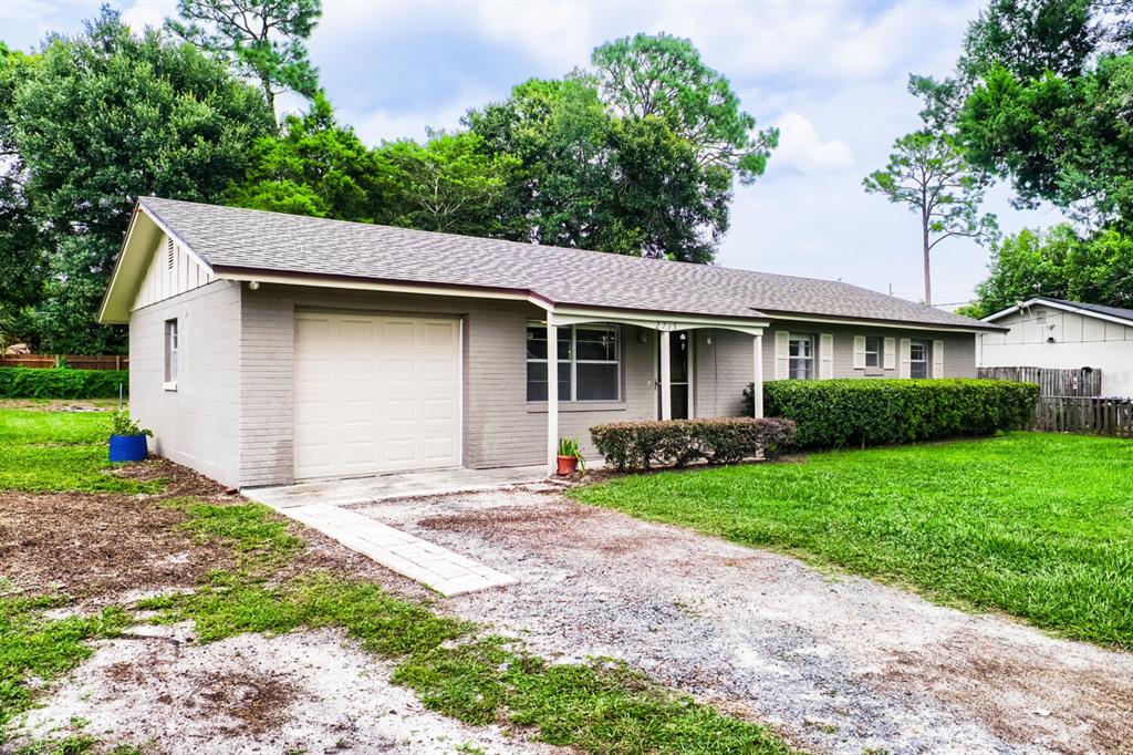 A single-story gray brick house features a one-car garage and a small front porch — 2715 RAMSEY DR, APOPKA, FL