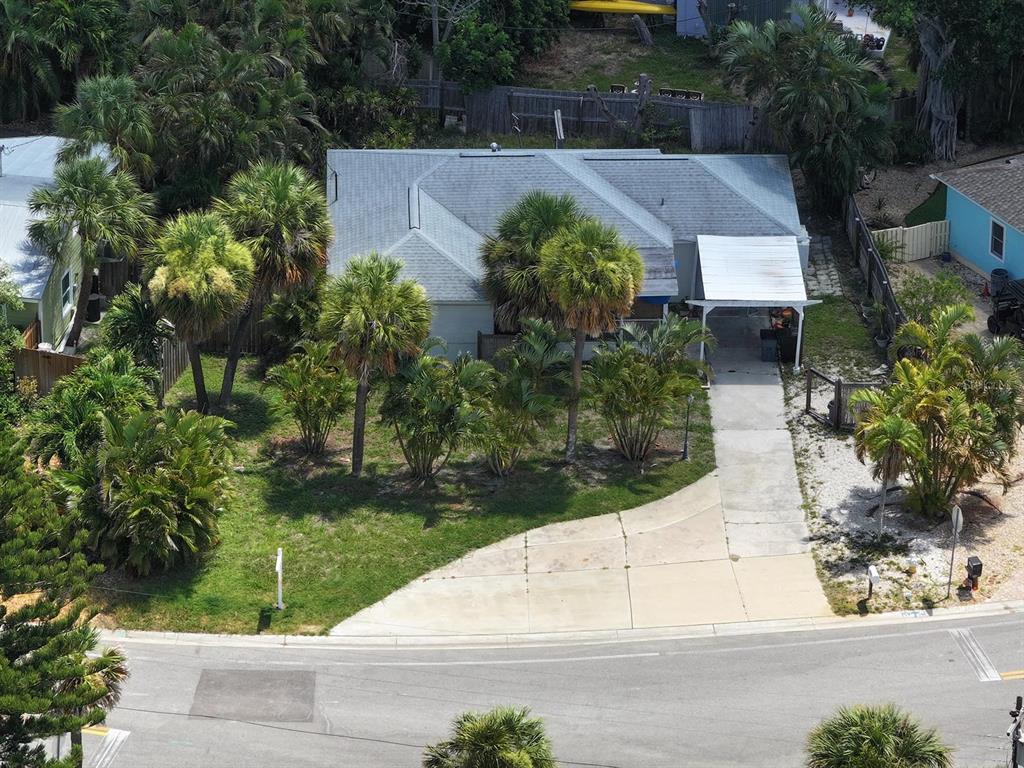 An aerial view of a single-story house with a gray roof and a concrete driveway — 3929 BELLE VISTA DRIVE, ST PETE BEACH, FL