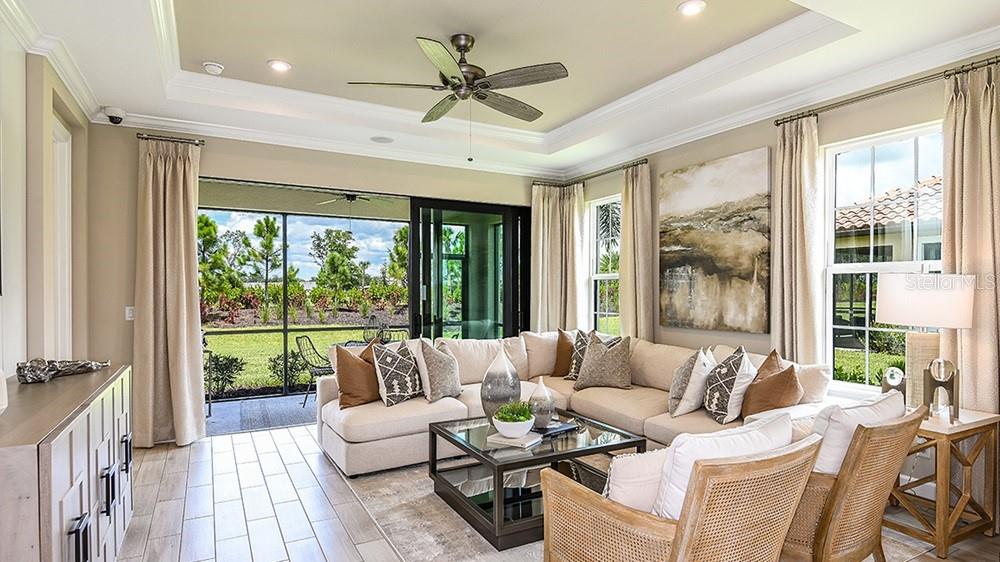 A living room features a sectional sofa, a coffee table, and a sliding glass door — 14525 DERNA TERRACE, BRADENTON, FL