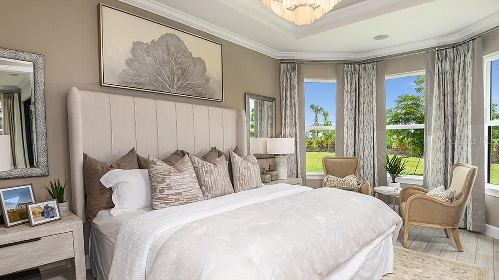 A bedroom features a tufted headboard, a bay window with curtains, and neutral decor — 14525 DERNA TERRACE, BRADENTON, FL