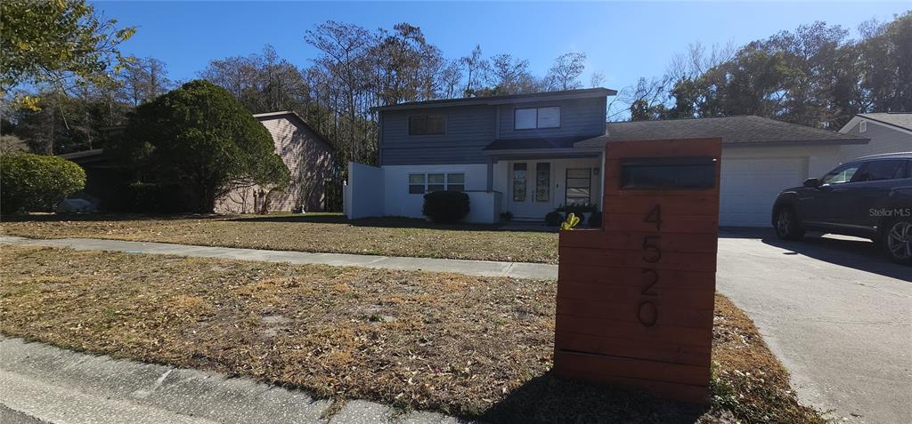 A two-story house with a wooden mailbox post in the foreground and a driveway — 4520 GRAINARY AVENUE, TAMPA, FL