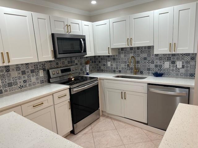 A kitchen with white cabinets, stainless steel appliances, and patterned tile backsplash — 251 Seville K # 251, Delray Beach FL 33446, DELRAY BEACH, FL