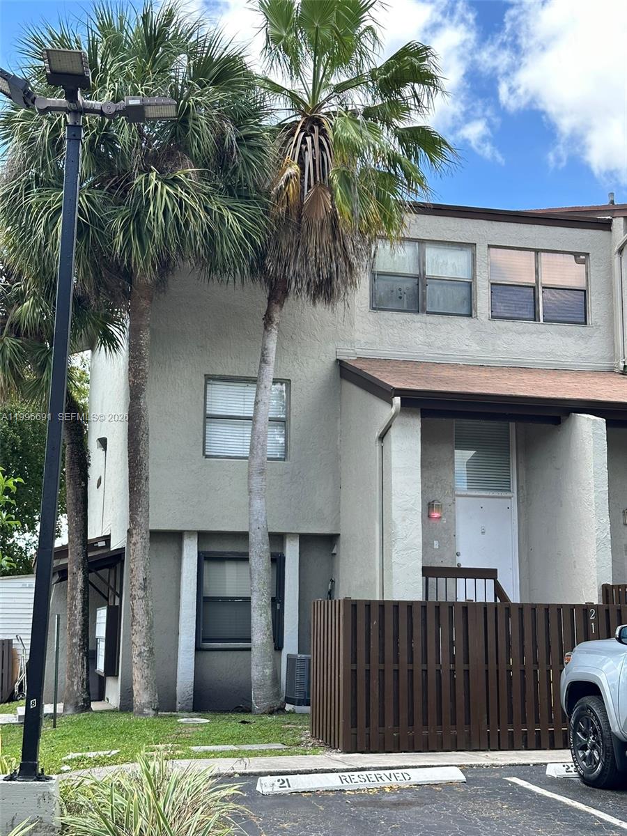 A two-story townhouse exterior features a reserved parking space and palm trees in front — 10000 NW 9th St Cir # 21, Miami FL 33172, MIAMI, FL
