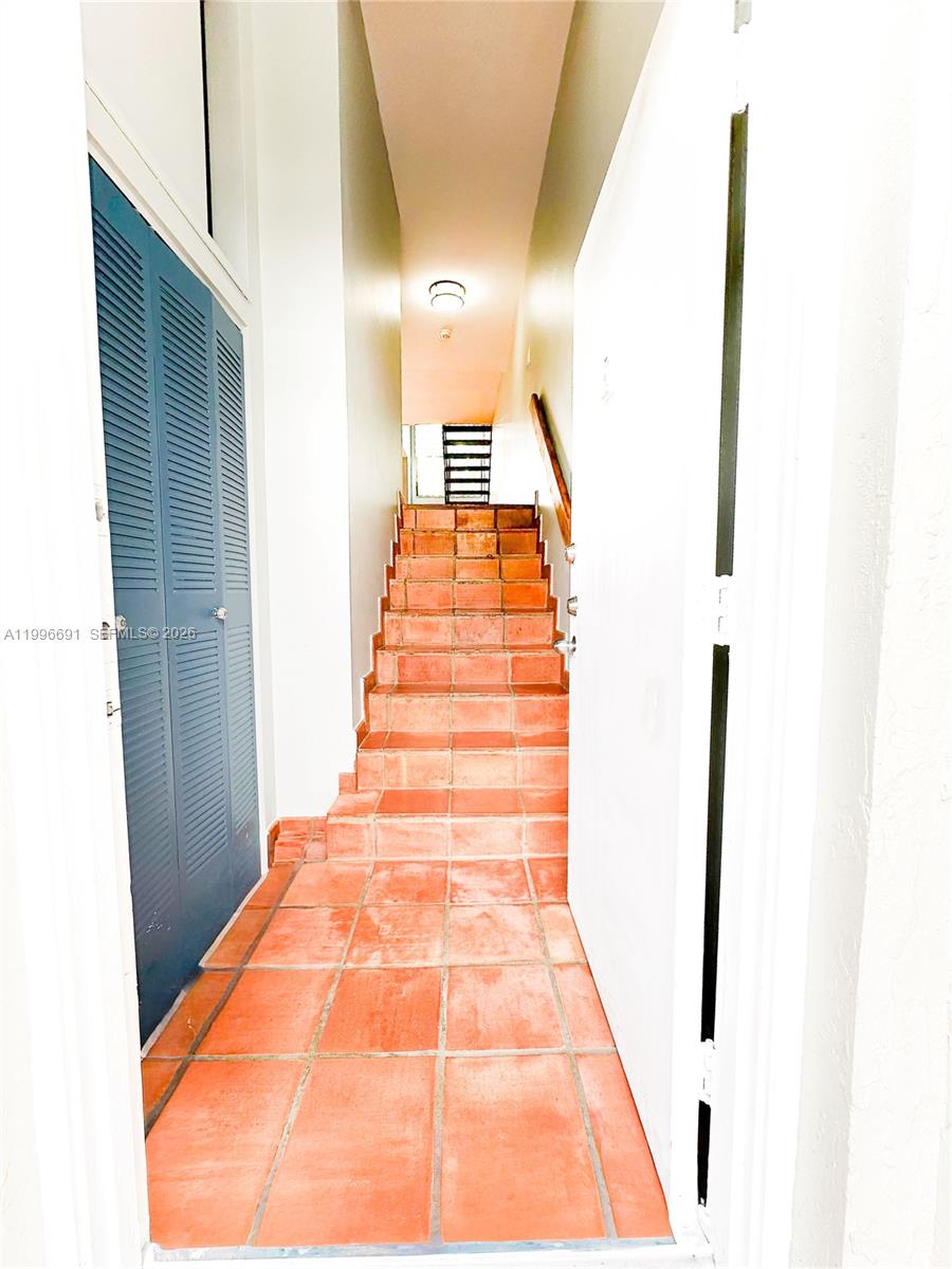 A narrow entryway features terracotta tile flooring leading to a set of stairs — 10000 NW 9th St Cir # 21, Miami FL 33172, MIAMI, FL