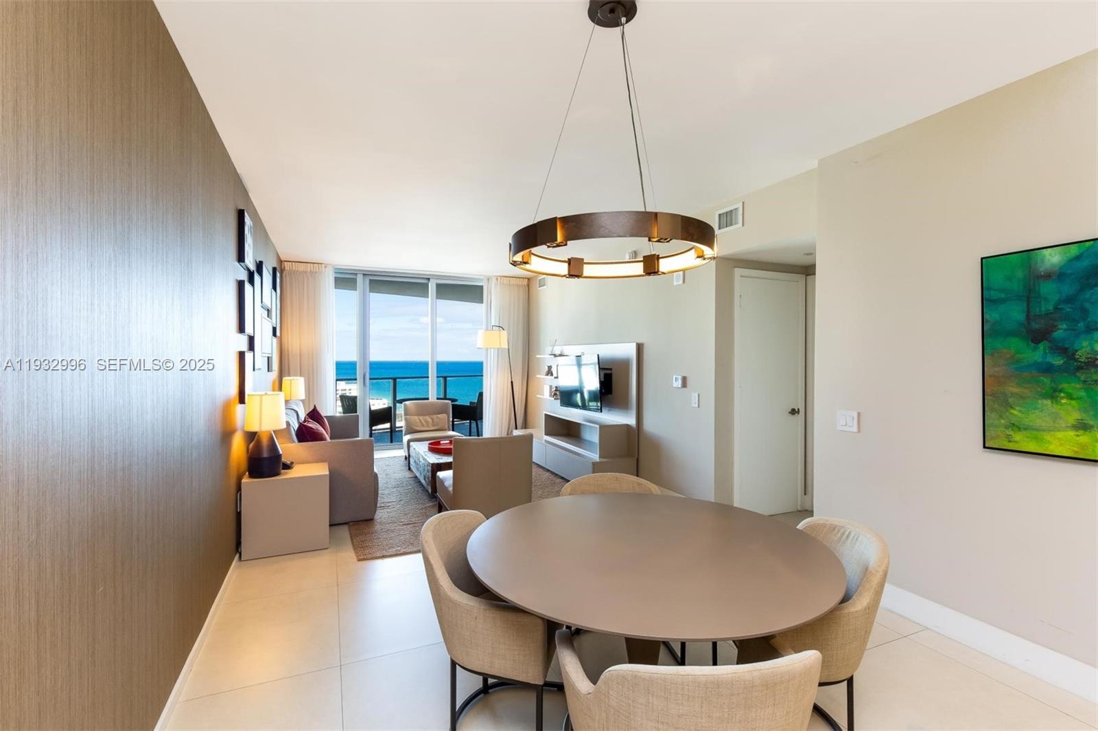 A dining area with a round table opens into a living room overlooking the ocean — 4111 S Ocean Dr # 1910, Hollywood FL 33019, HOLLYWOOD, FL