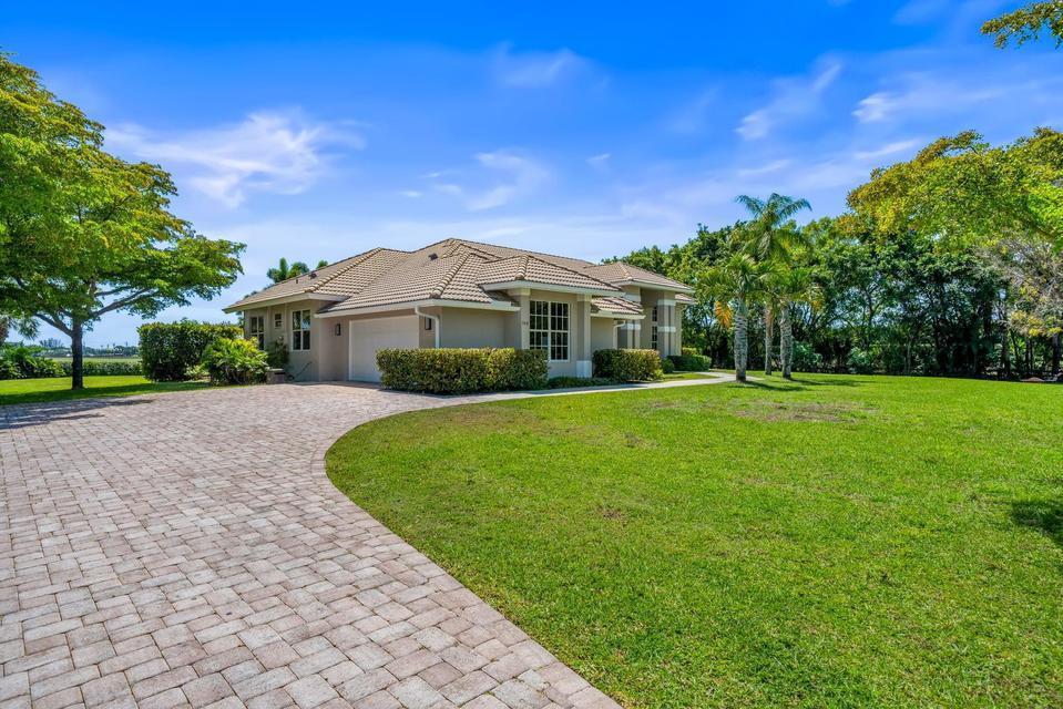 A beige single-story house with a tiled roof and a brick paver driveway — 3950 Fieldview Way, Wellington FL 33414, WELLINGTON, FL