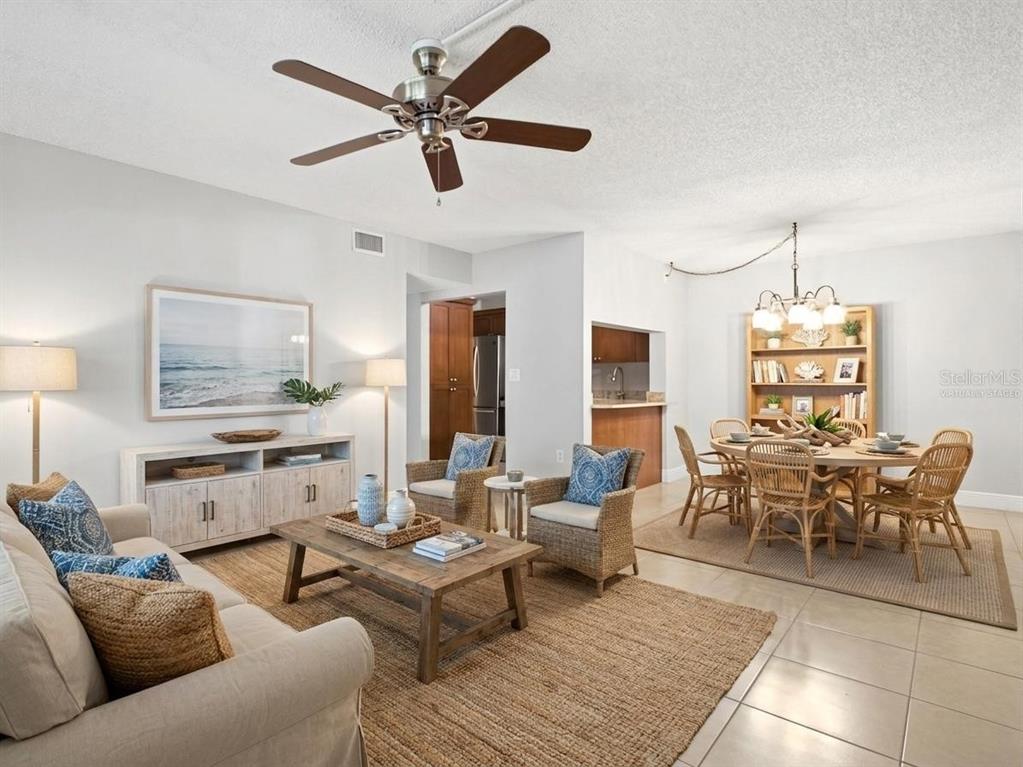 A living and dining area with a ceiling fan, wicker chairs, and a wooden table — 3101 LAKE PINE WAY UNIT A1, TARPON SPRINGS, FL