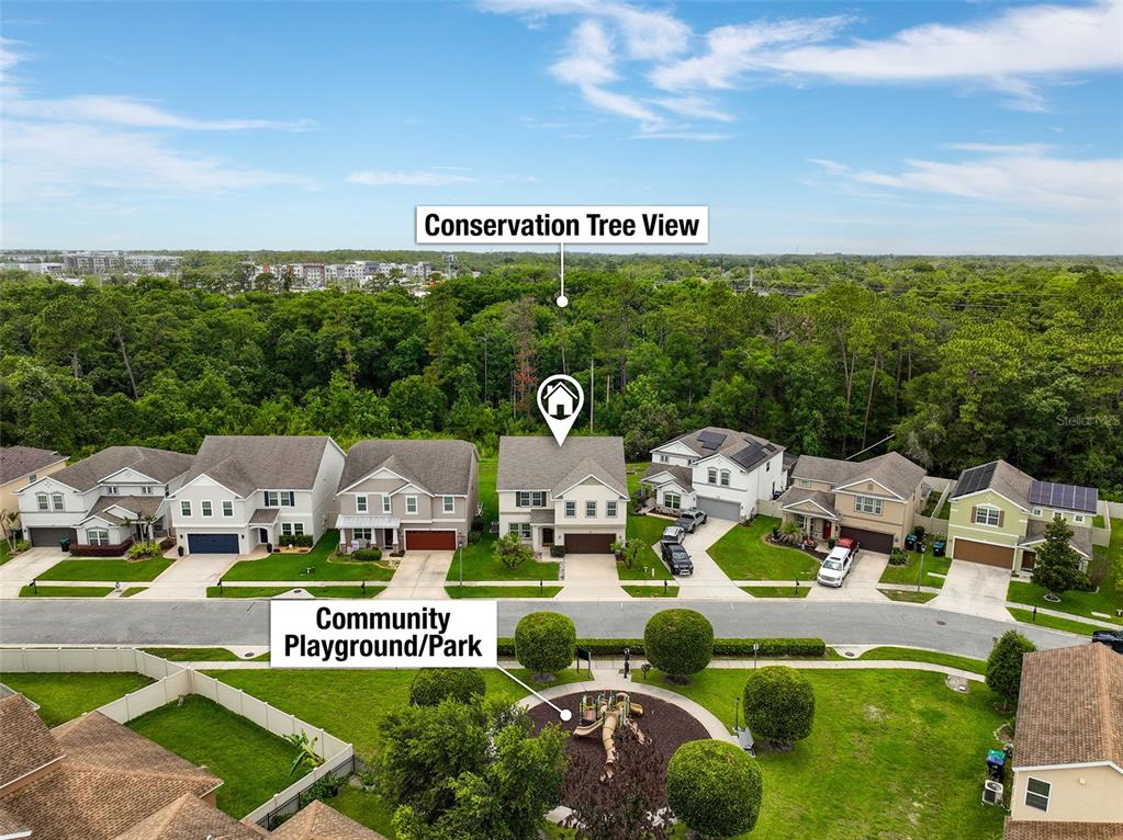 An aerial view shows a row of suburban houses facing a community playground and park — 14048 WATERFORD CREEK BOULEVARD, ORLANDO, FL