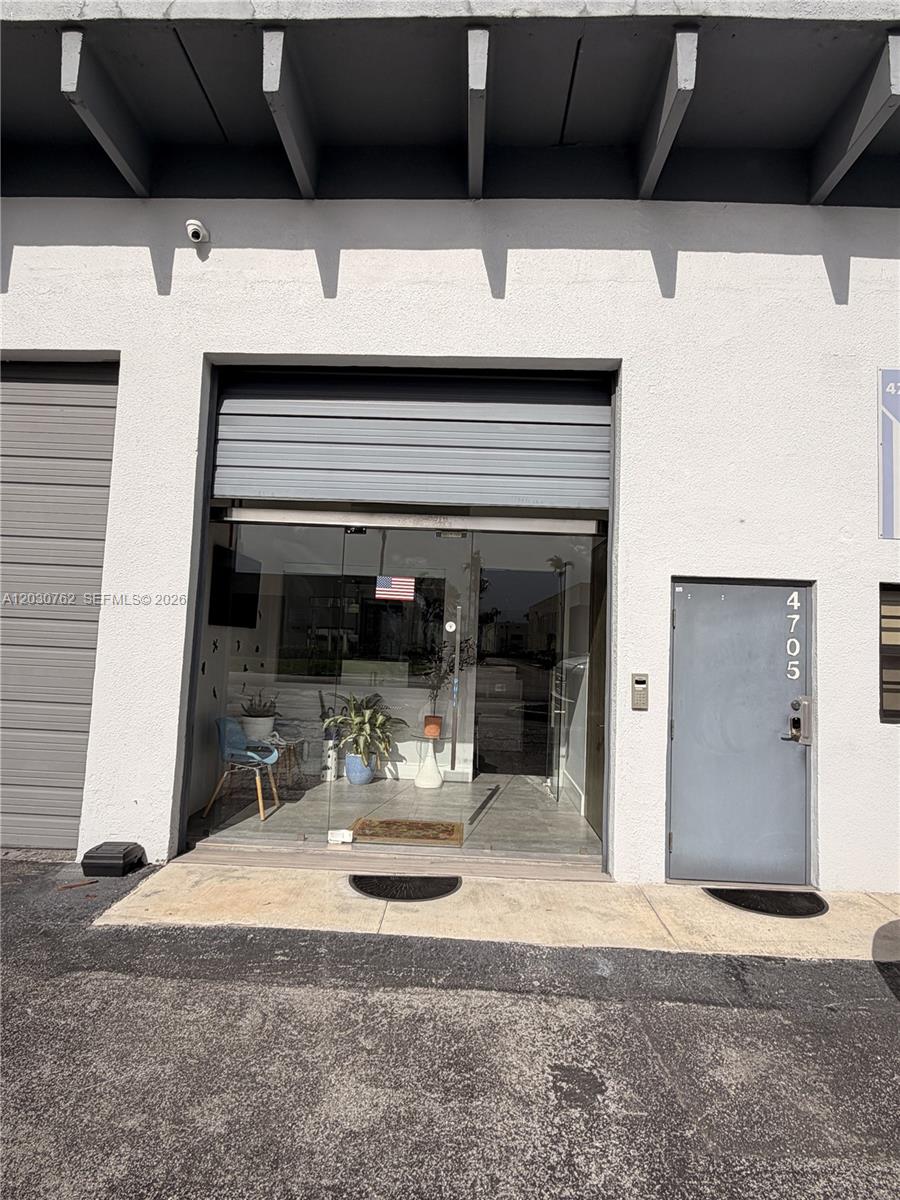 An exterior view of a commercial building entrance with a glass door and adjacent metal door — 4709 SW 74th Ave, Miami FL 33155, MIAMI, FL