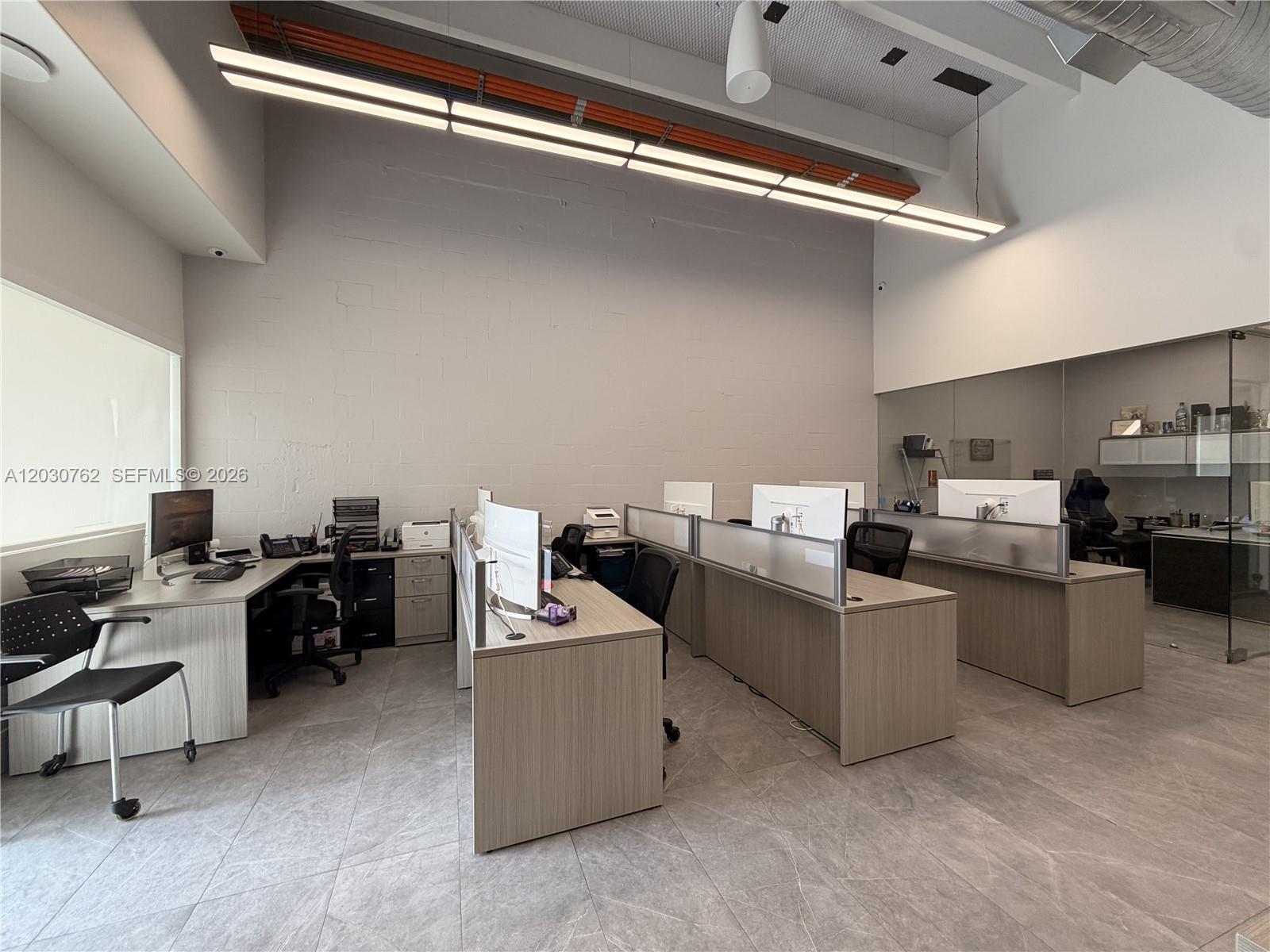 An office space features three rows of desks with computers, grey tiled floors, and high ceilings — 4709 SW 74th Ave, Miami FL 33155, MIAMI, FL