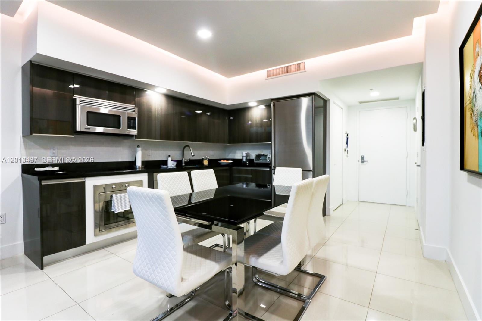 A modern kitchen features dark wood cabinetry, stainless steel appliances, and a black dining set — 92 SW 3rd St # 2808, Miami FL 33130, MIAMI, FL