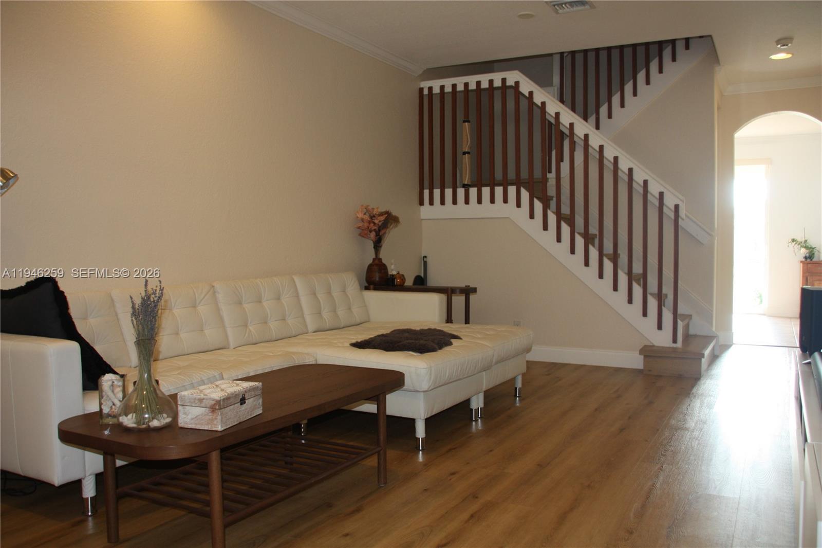 A living room features a white sectional sofa, a wooden coffee table, and a staircase — 7414 E Briella Dr, Boynton Beach FL 33437, BOYNTON BEACH, FL