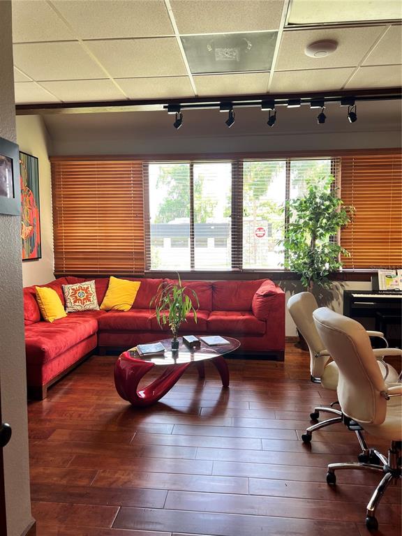 A living room features a red sectional sofa, a glass coffee table, and hardwood flooring — 377 MAITLAND AVENUE UNIT 1010, ALTAMONTE SPRINGS, FL