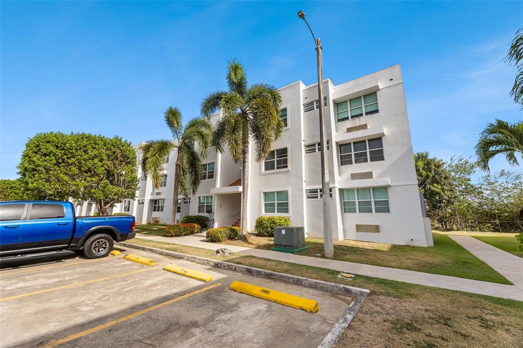 A three-story white apartment building with palm trees and a blue truck in the foreground — Jurel #500 ST. COND. VEREDAS DEL MAR APT 3-307, VEGA BAJA, PR