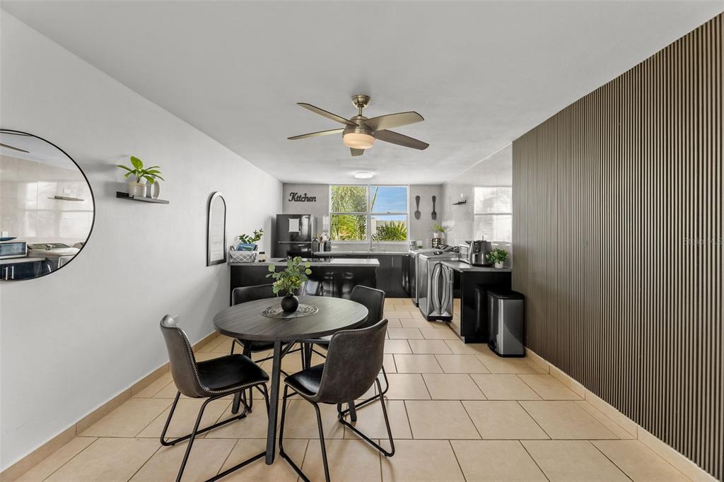 A dining area with a round table and chairs sits adjacent to a modern kitchen — Jurel #500 ST. COND. VEREDAS DEL MAR APT 3-307, VEGA BAJA, PR