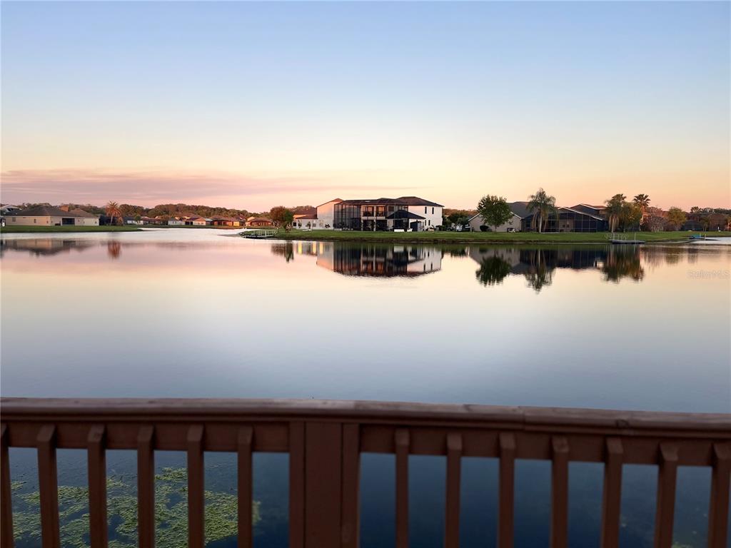 A view of a calm lake with houses on the far shore at sunset — 2860 BOATING BOULEVARD, KISSIMMEE, FL