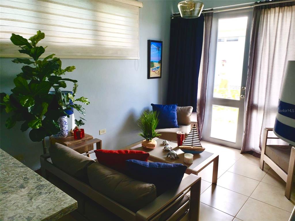 A living room features a sofa, coffee table, armchair, and a glass door to outside — Carr. PR 307 km 8.5 BOQUERÓN BAY SIDE INC APT #23, CABO ROJO, PR