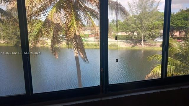 A view of a lake and palm trees through a large window — 8335 SW 152nd Ave # 310, Miami FL 33193, MIAMI, FL