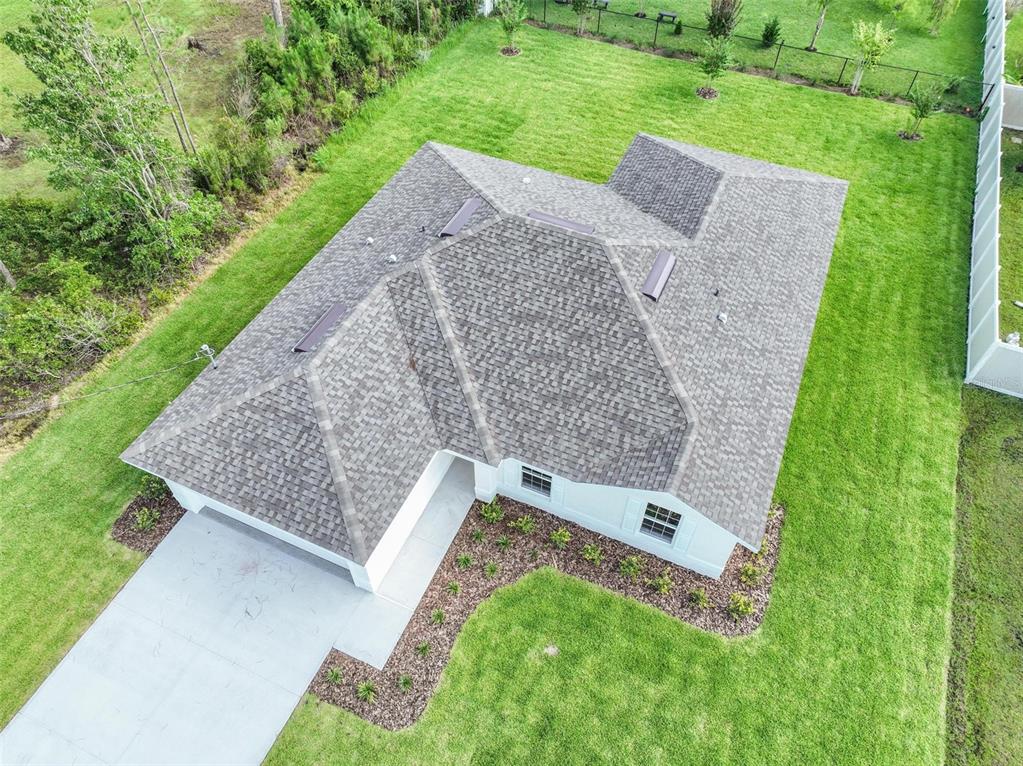 An aerial view shows a single-story house with a shingled roof and a concrete driveway — 134 RED MILL DRIVE, PALM COAST, FL