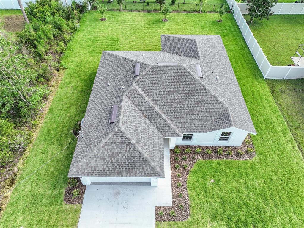An aerial view shows a single-story house with a gray shingled roof and a driveway — 134 RED MILL DRIVE, PALM COAST, FL