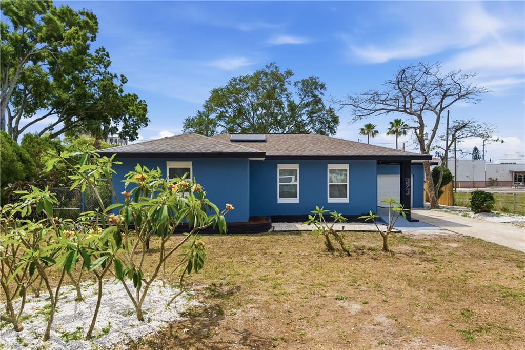 A blue, single-story house with a dark roof, white-trimmed windows, and a front yard — 923 1ST AVENUE NW, LARGO, FL