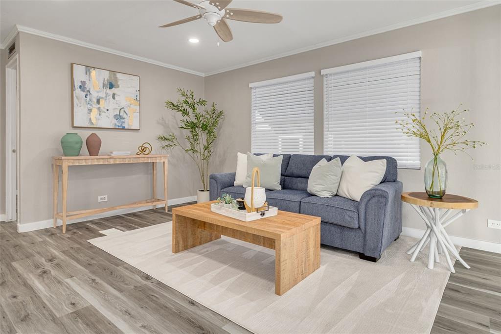 A living room features a blue sofa, a wooden coffee table, and light wood flooring — 29250 US HIGHWAY 19 N UNIT 537, CLEARWATER, FL