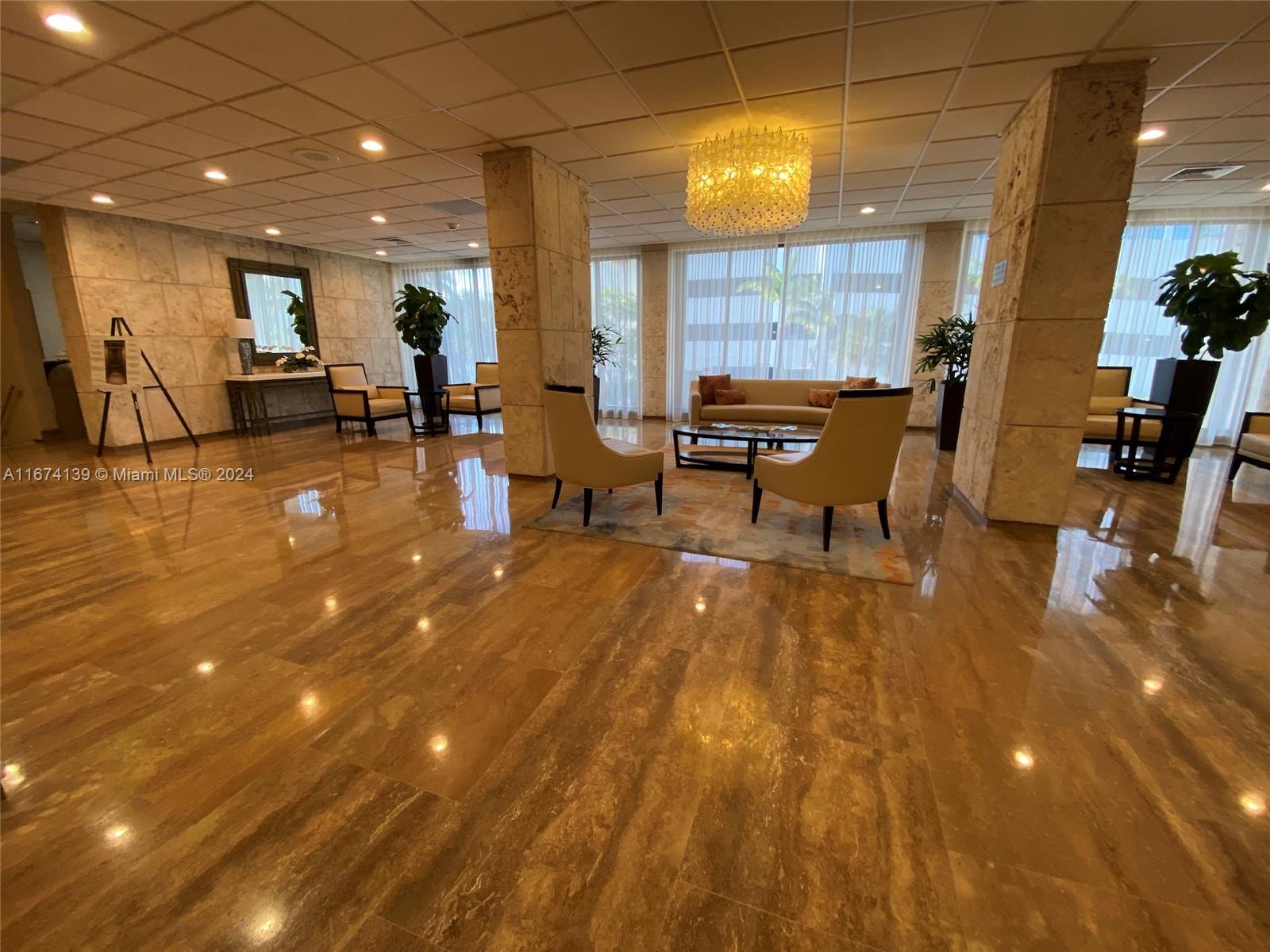 A lobby features polished stone floors, square columns, and a seating area with modern furniture — 1965 S Ocean Dr # 4D, Hallandale Beach FL 33009, HALLANDALE BEACH, FL
