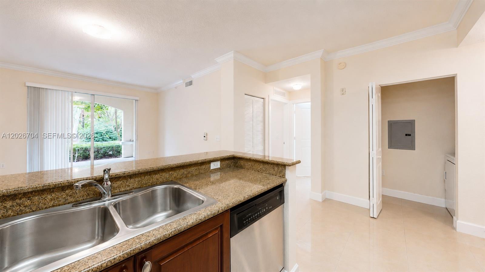 A kitchen with granite countertops and stainless steel appliances overlooks a living area with patio access — 4106 Renaissance Way # 106, Boynton Beach FL 33426, BOYNTON BEACH, FL