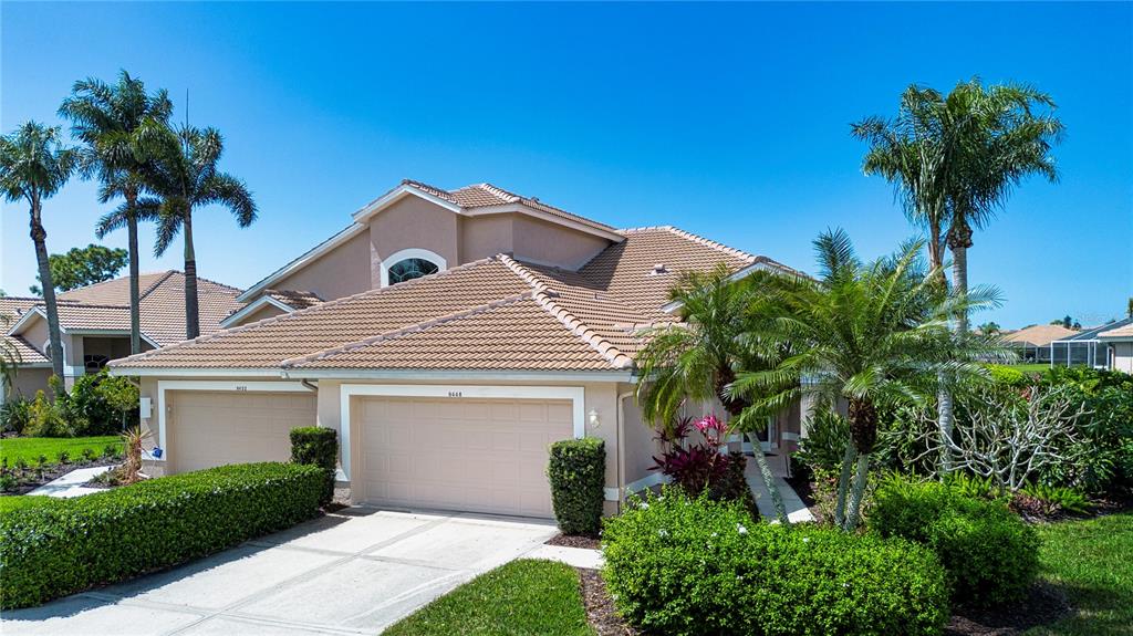A covered patio features outdoor furniture, a blue area rug, and a view of a pool — 9448 FOREST HILLS CIRCLE, SARASOTA, FL