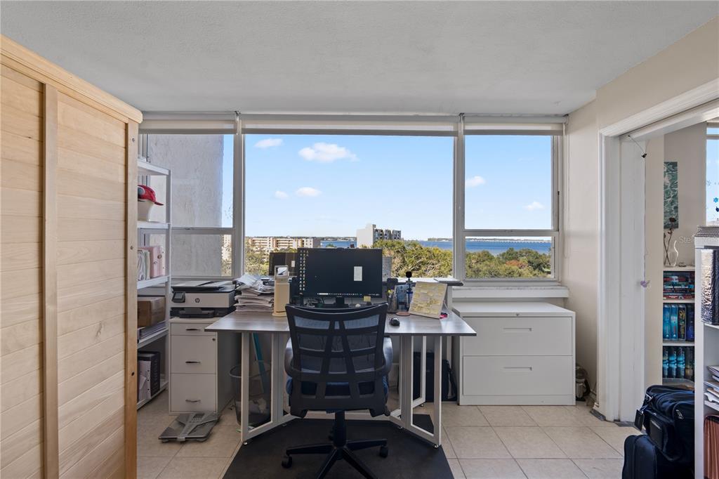 A home office with a desk, computer, and large windows overlooking a water view — 2621 COVE CAY DRIVE UNIT 804, CLEARWATER, FL