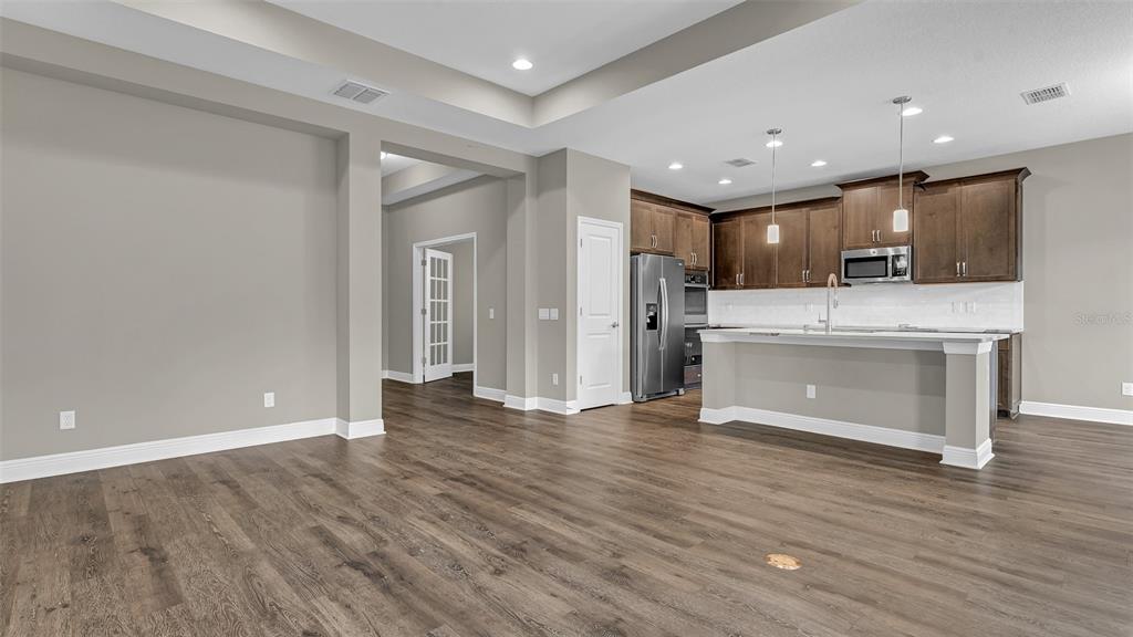 A kitchen with dark wood cabinets, stainless steel appliances, and a large island with seating — 19455 REDWOOD POINT DRIVE, TAMPA, FL