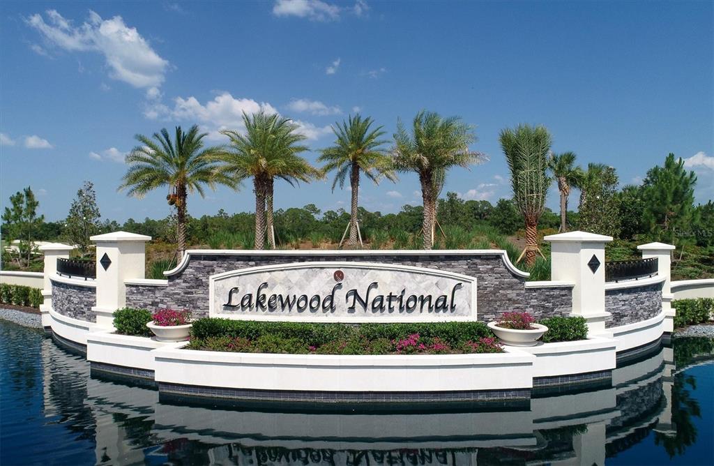 The entrance sign for Lakewood National features stone masonry, white pillars, and palm trees — 17006 VARDON TERRACE UNIT 402, BRADENTON, FL